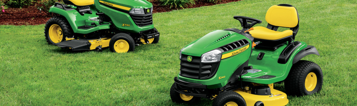 Two John Deere Select Series mowers parked on a lush lawn.